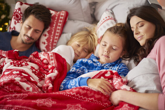 封闭在圣诞节的早晨睡觉的家人女儿睡衣向下