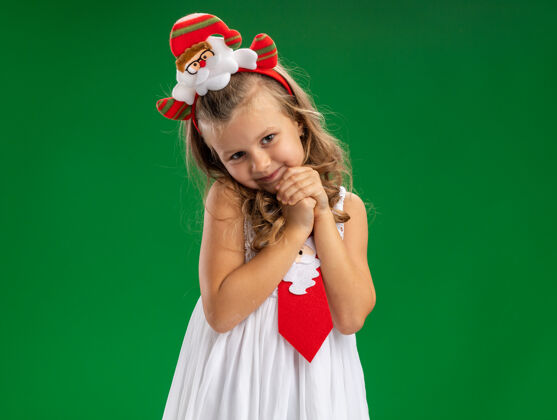 快乐高兴的小女孩戴着圣诞发箍打着领带 手牵着手孤立地放在绿色的背景上抱着在一起圣诞节