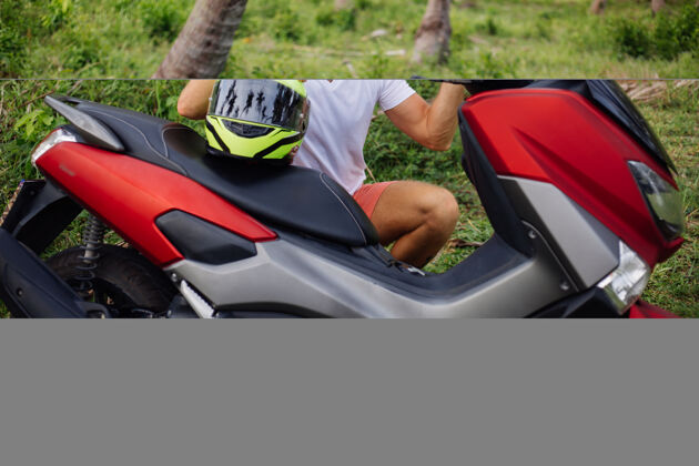 保护在热带丛林地带骑着红色摩托车的壮汉头盔度假景观