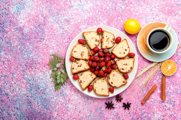 派顶视图蛋糕片与新鲜草莓和咖啡杯上粉红色的办公桌蛋糕烤甜饼干颜色派糖饼干盘子营养品饼干