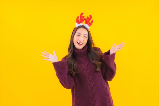 庆祝肖像美丽的亚洲年轻女子穿圣诞装饰主题手势帽子漂亮