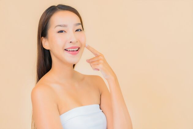 女人肖像美丽的年轻亚洲女子在温泉与自然化妆米色皮肤护理水疗衰老