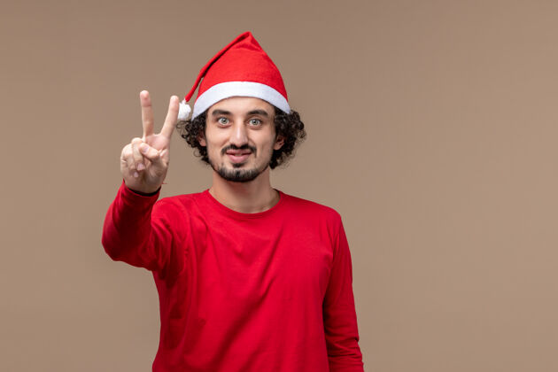 微笑正面图红色的男性在棕色背景上显示数字圣诞节职业快乐男性
