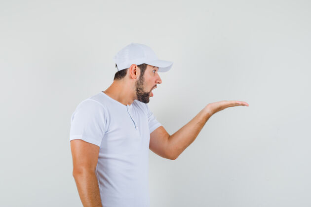 人一个穿着白色t恤的年轻人 举着一只手在一旁询问 表情严肃男人肖像现代