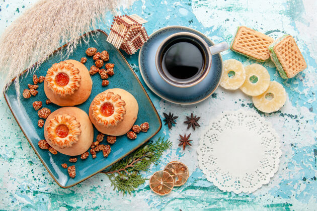 顶部俯瞰美味饼干与干菠萝环华夫饼和咖啡在蓝色表面饼干饼干甜甜的糖的颜色曲奇棉花饼干