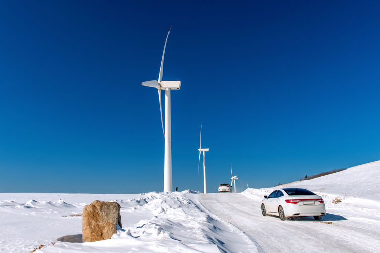 领域风机和汽车在冬天的蓝天景观供应发电能源