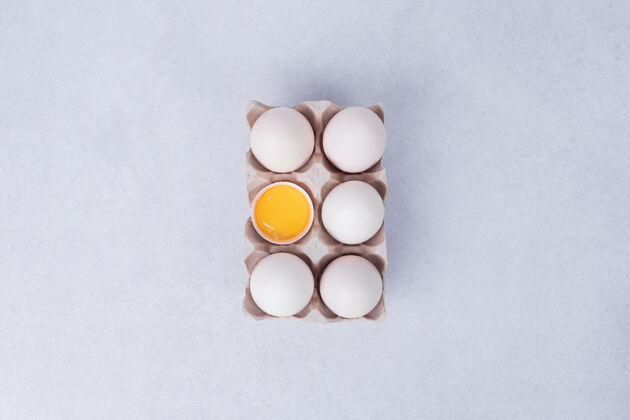 顶部视图鸡蛋放在白色的纸容器里生的家禽视图