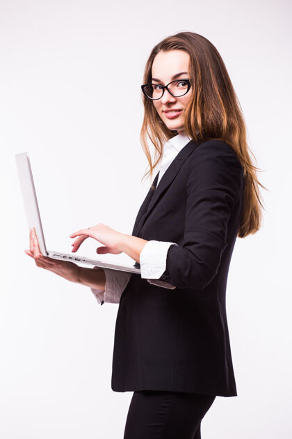 笔记本电脑成功的女商人是站在孤立的墙上的笔记本电脑秘书公司