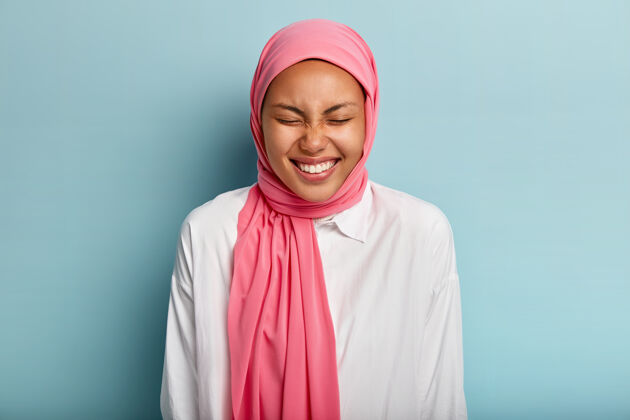 迷人的阿拉伯女性笑容可掬 闭上眼睛 表达美好的情感高兴一瞥围巾