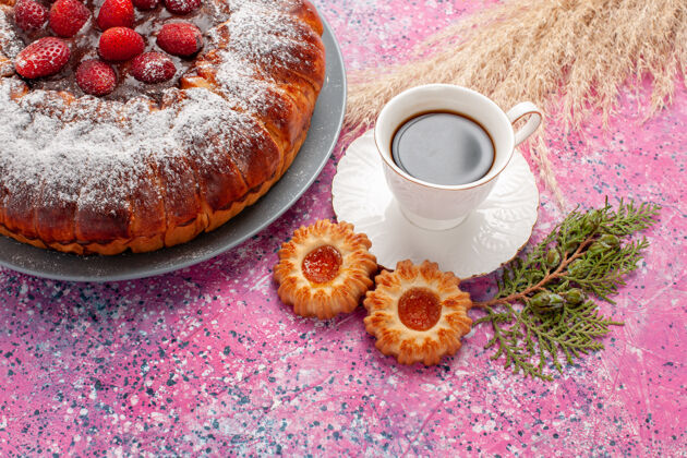 餐正面是美味的草莓蛋糕 上面有饼干和一杯茶 粉色的蛋糕 甜甜的甜甜的饼干 馅饼饮料咖啡草莓