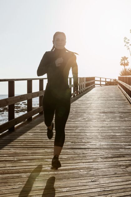 训练前视图的运动妇女慢跑的海滩与复制空间女人跑步运动