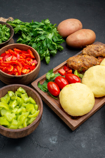 美味肉片深色桌子上美味的蔬菜肉排和一束绿色蔬菜的垂直视图饮食餐桌蔬菜