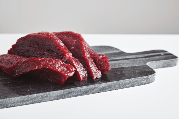 有机在白色桌子上的大理石切割板上切割优质生鲸鱼肉牛排特写 侧视图桌子块屠宰