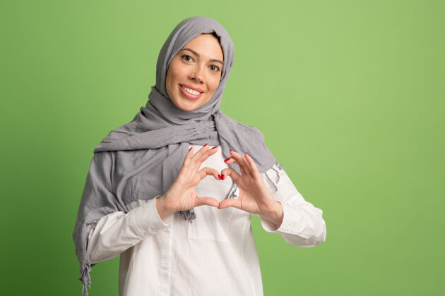 情绪化戴着头巾的快乐阿拉伯女人微笑女孩的肖像 在绿色工作室摆姿势伊斯兰围巾