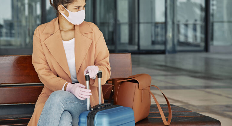 旅行大流行期间在机场戴手套和医用口罩的妇女女性冠状病毒旅行
