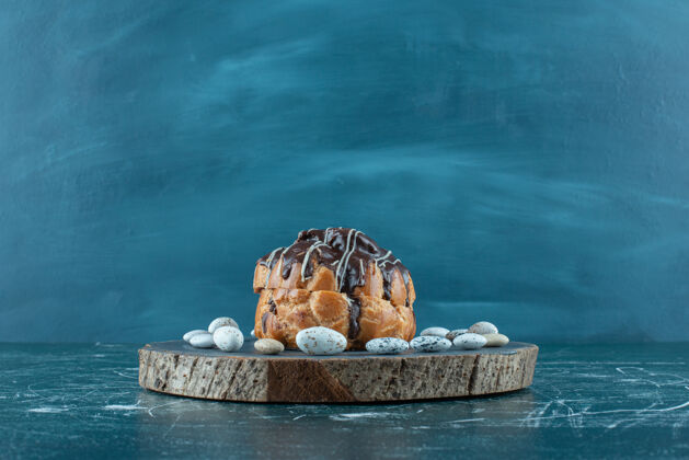 蛋糕巧克力蛋糕和糖果块放在蓝色的木板上配料点心巧克力