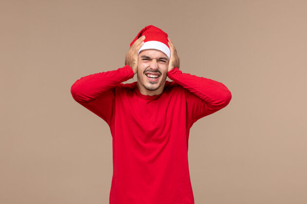 帽子正面图棕色背景上表情激动的年轻男性圣诞假期感慨成人漂亮背景