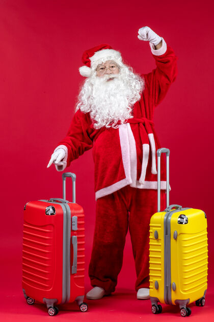 时尚带着两个袋子的圣诞老人正准备在红墙上旅行快乐服装假期