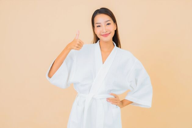 女士肖像美丽的亚洲年轻女子穿着米色的微笑浴袍皮肤日本诊所