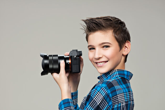 相机男孩拿着相机拍照高加索男孩的肖像 手里拿着数码相机图片男性男孩