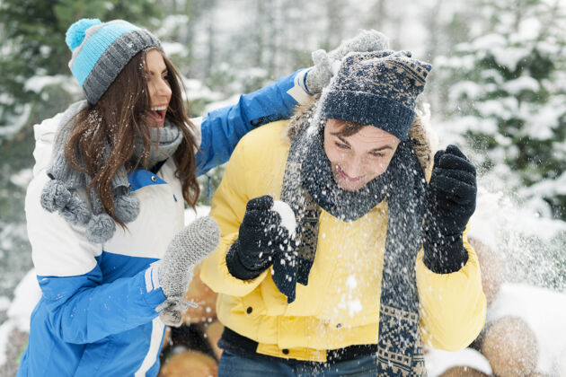 欢笑这对年轻夫妇在打雪仗时玩得很开心浪漫服装寒冷