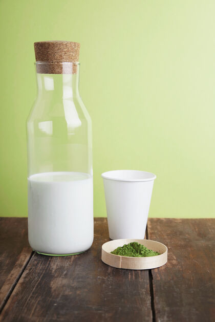 木材古董奶瓶 白纸外卖玻璃和有机优质抹茶粉在棕色拉丝木桌前的绿色简单的背景饮食玻璃饮料