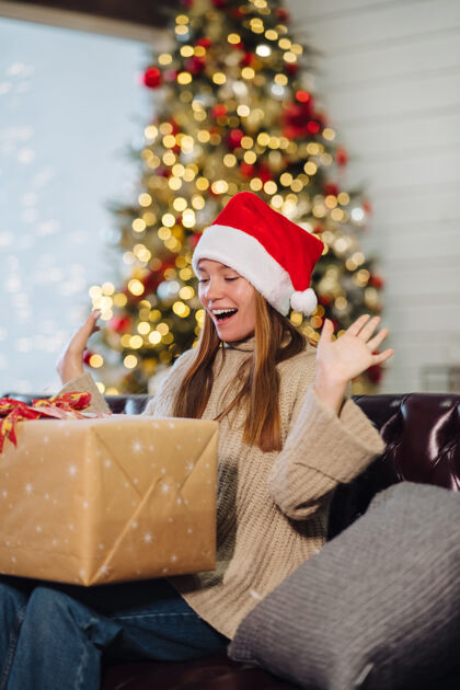 年轻人在除夕夜拿着圣诞礼物的女孩惊喜盒子松树