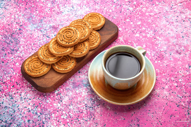内衬半俯视圆甜饼干美味的小饼干与茶内衬在粉红色的办公桌上饮料小杯子