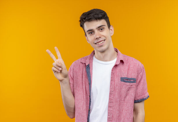 手势微笑的白人年轻人穿着粉色衬衫 在孤立的橙色背景下展示和平姿态展示粉色和平