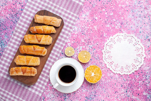 美味俯瞰美味的百吉饼和一杯茶在粉红色的背景上烘焙面团饼干