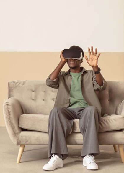 耳机戴着虚拟现实耳机坐在沙发上工作室非洲裔美国人非洲