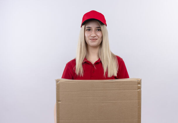 高兴一个穿着红色t恤和帽子的年轻女孩在孤立的白色背景下拿着盒子盒子送货女孩