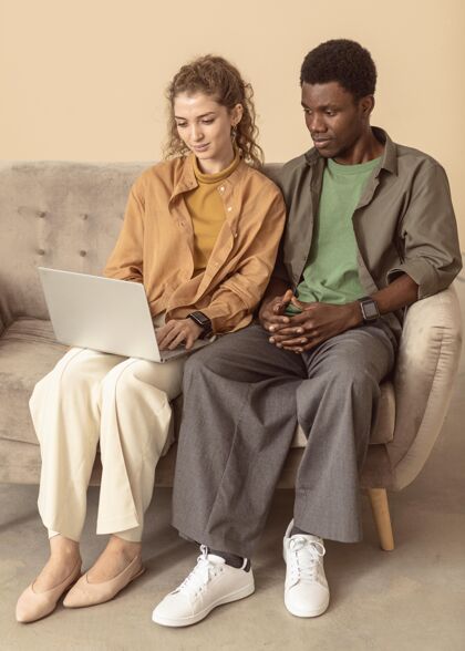非洲男人和女人坐在沙发上用笔记本电脑室内室内男人