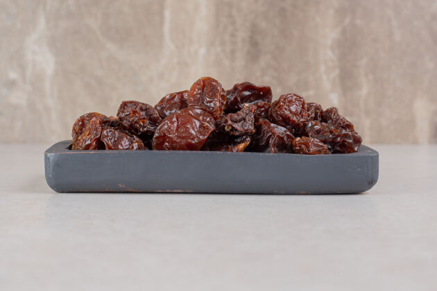 美味棕色干樱桃放在木盘上品质热带有机