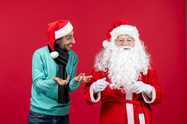 圣诞老人正面图：圣诞老人和年轻的男性站在一起男人圣诞老人节日