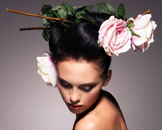 头发一个有创意发型的漂亮黑发女人的肖像花玫瑰深色