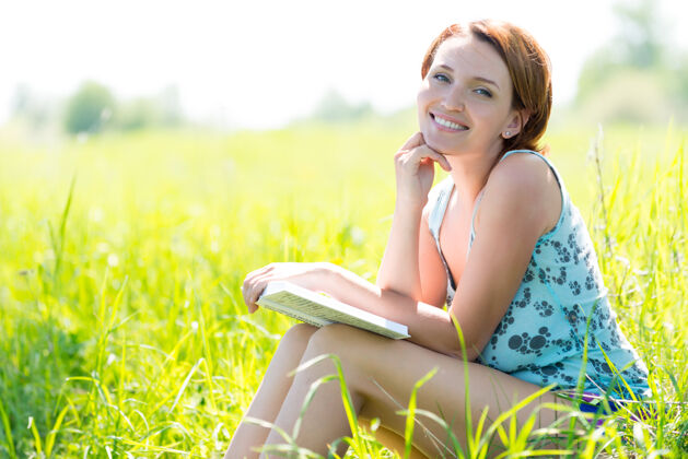 自然美丽微笑的女人在大自然里看书水平草地田野