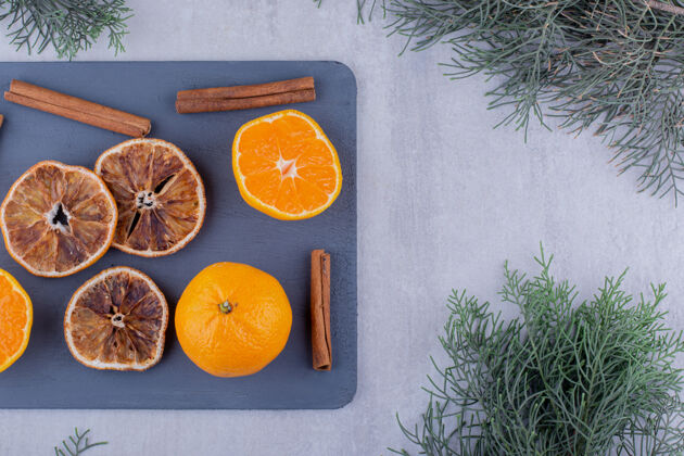 有机肉桂棒与多汁的橙子和干片在砧板上的白色背景高品质的照片可口开胃健康