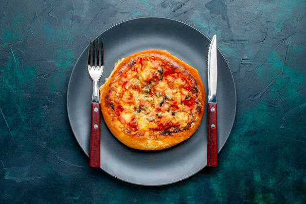 晚餐小奶酪比萨饼圆内形成深蓝色表面板顶视图营养品奶酪深色