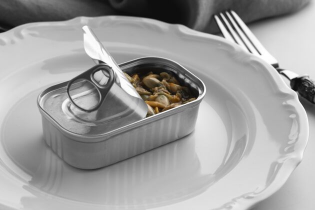 铝用叉子把食物放在盘子里的高角度罐头钢戒指水平