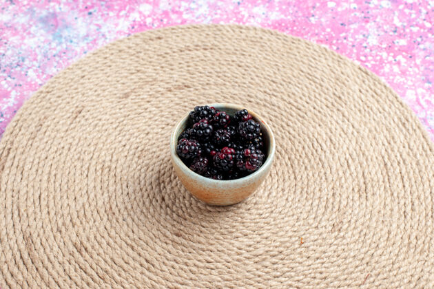 织物在粉红色桌子上的小罐子里看到新鲜的黑莓前面粗麻布