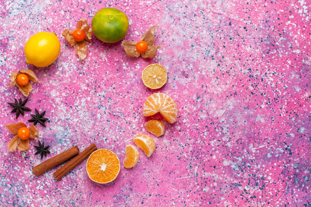 橘子在浅粉色的背景上俯瞰新鲜的酸橘子和柠檬和肉桂新鲜五颜六色柠檬
