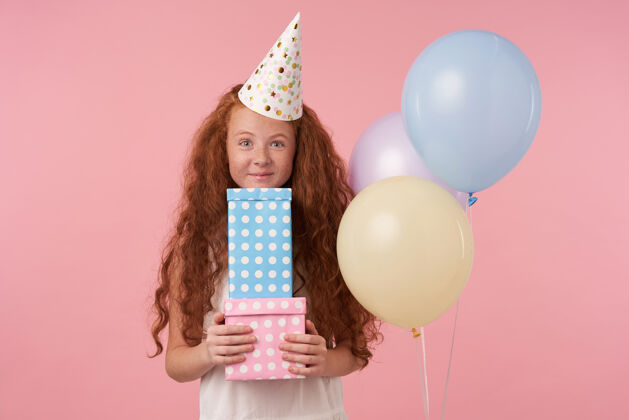 有色喜气洋洋的红发女孩儿手拿礼品包装盒 惊喜地收到许多生日礼物 穿着喜庆的衣服 精神抖擞孩子和庆祝的概念童年高兴室内