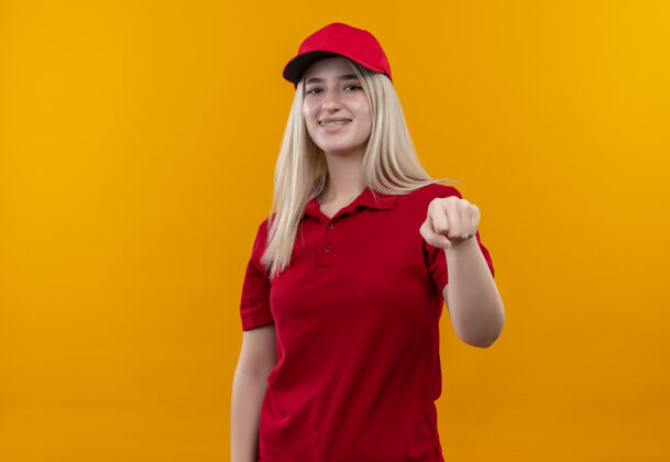 穿着一个身穿红色t恤 头戴帽子的年轻女孩 在孤立的橙色背景下 手举拳头对着镜头 面带微笑帽子橙色微笑