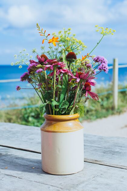 花园特写镜头一个美丽的花盆与花在木桌上空房子花