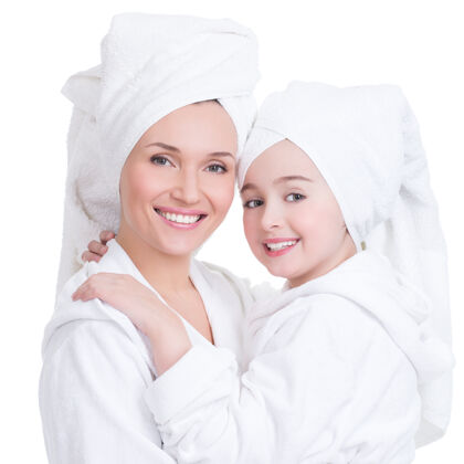晨衣身着白色晨衣和毛巾的快乐母亲和小女儿的肖像-孤立毛巾晨衣洗澡