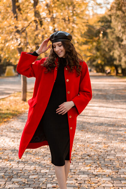 服装迷人的时尚微笑的女人卷发漫步在公园穿着温暖的红色外套秋季时尚 街头风格 戴贝雷帽配饰女人秋天