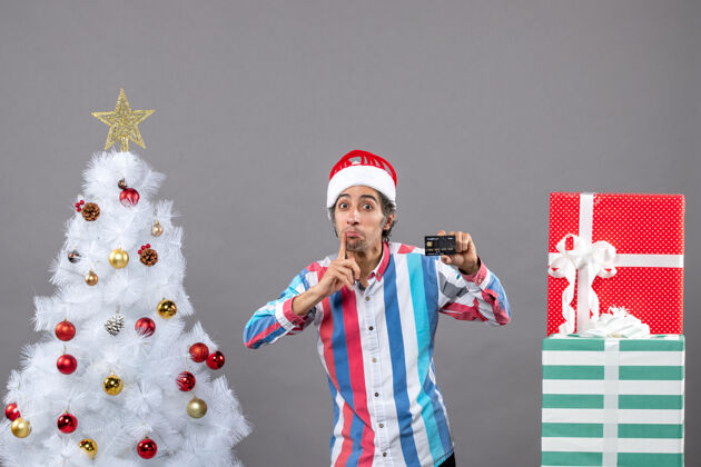 男性前视图男子与窥视卡站在白色圣诞树附近的眼睛站立眼睛火炬