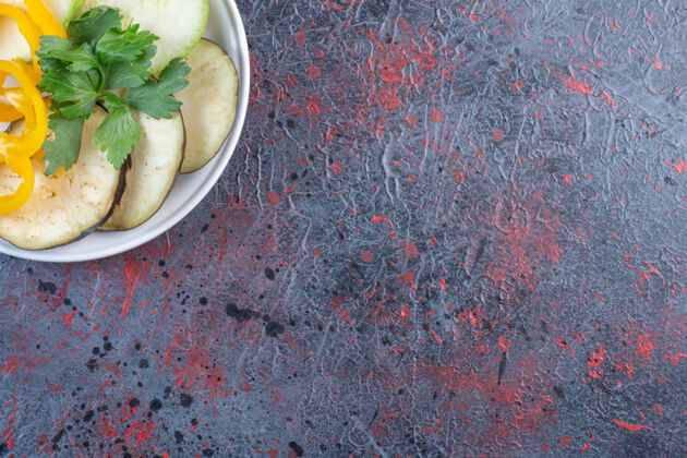 天然茄子和甜椒片 配一小包欧芹 放在黑桌子上的盘子里饮食有机营养