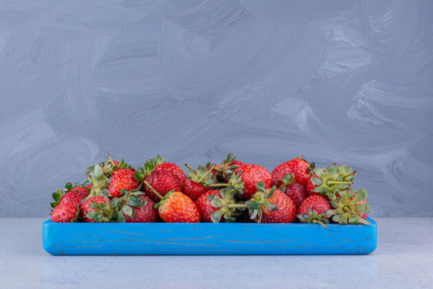 水果蓝色小盘 大理石背景上有一部分草莓拼盘美味天然